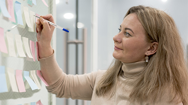 Woman organizing with post-it notes on a white board